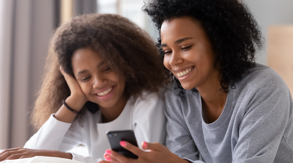 Parent et enfant qui regarde l'écran d'un téléphone cellulaire
